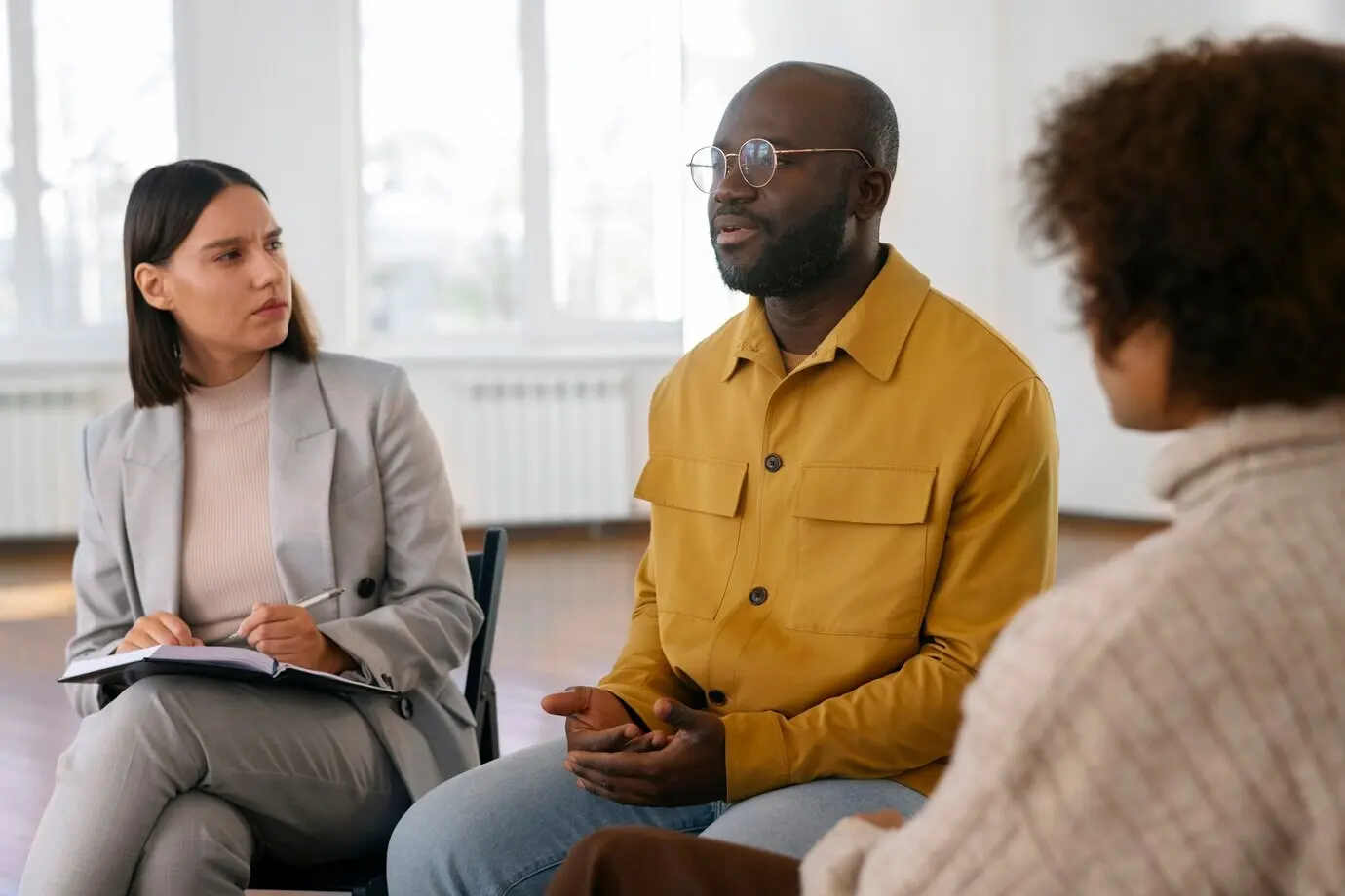 Люди делятся чувствами и эмоциями во время сеанса групповой терапии.